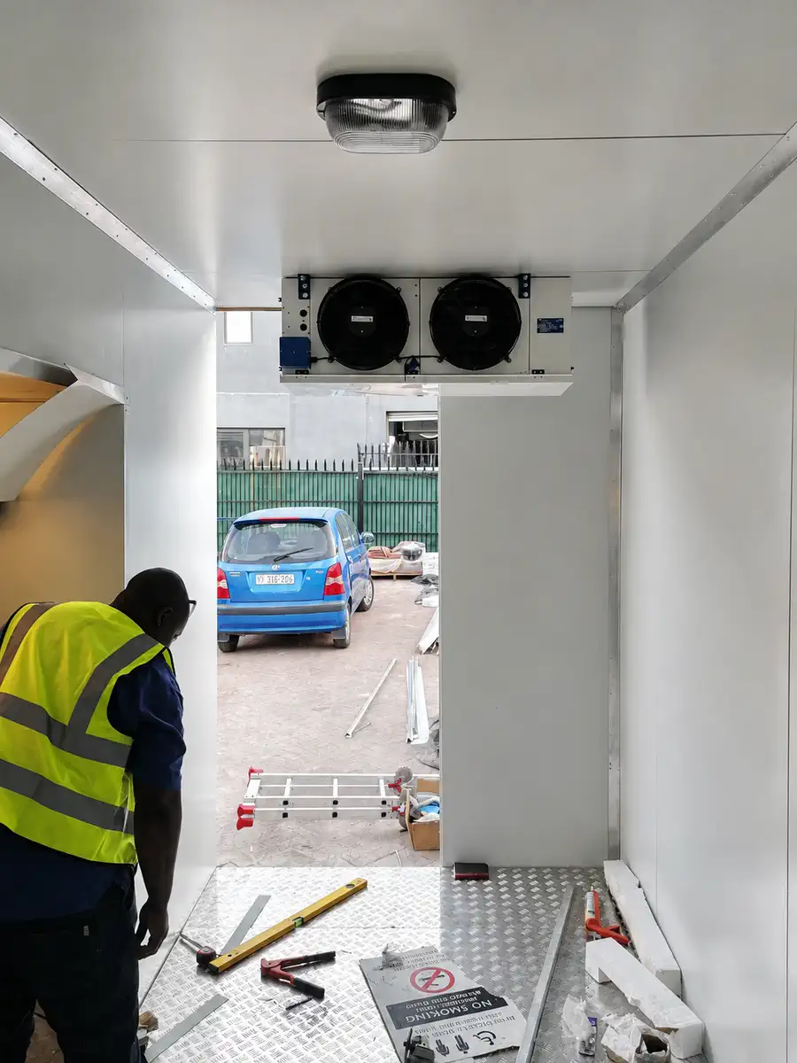 Technician completing a commercial cold-room evaporator installation