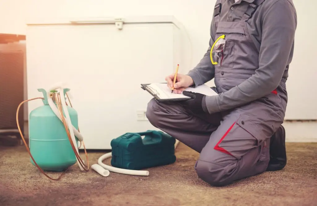 Technician assessing a fridge freezer for emergency repair in Cape Town